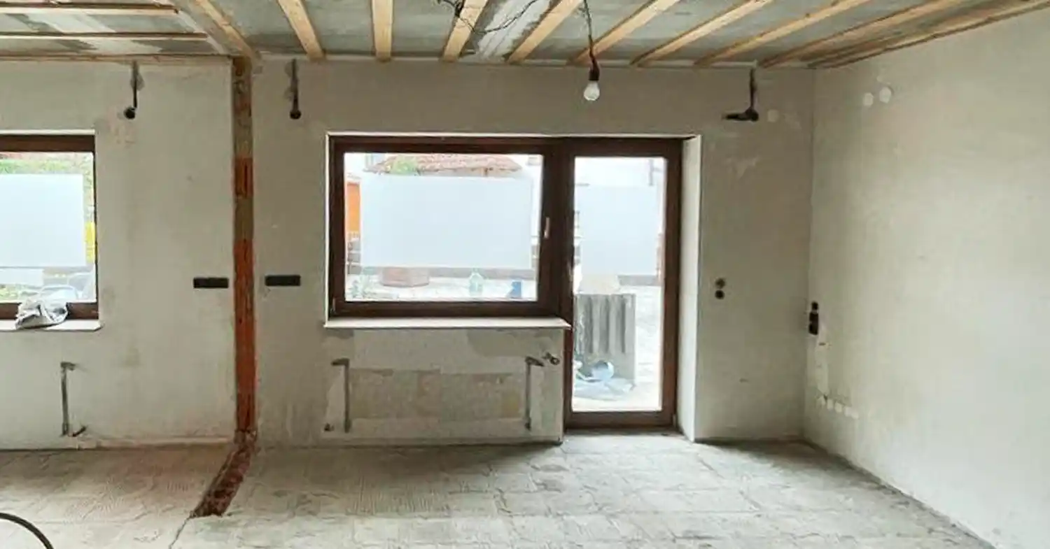 Wohnzimmer nach der Entkernung durch die Altbewährt GmbH – Bodenbeläge und Wandverkleidungen entfernt, Rohbauzustand