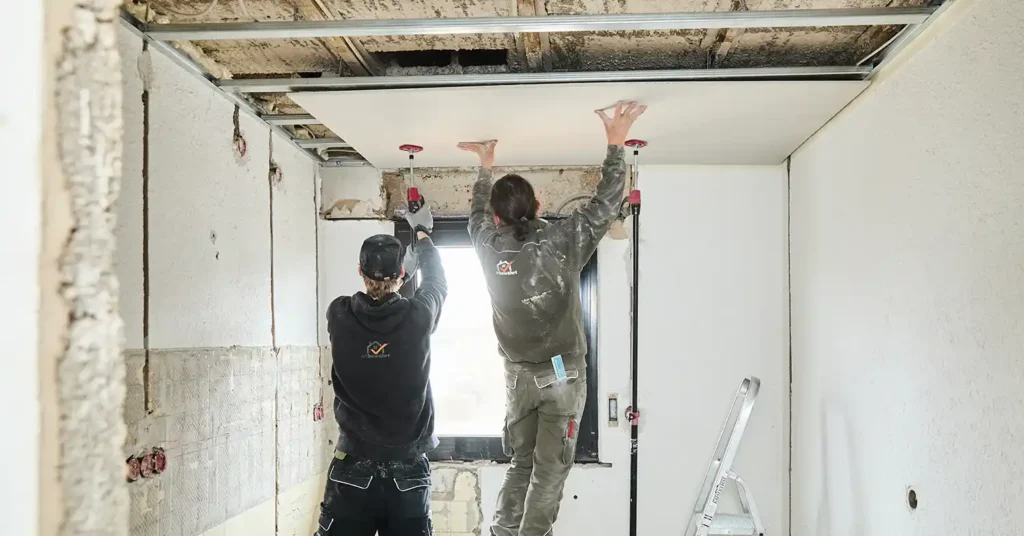 Altbewährt GmbH Trockenbau - Mitarbeiter bringen Rigipsplatten an der Decke an